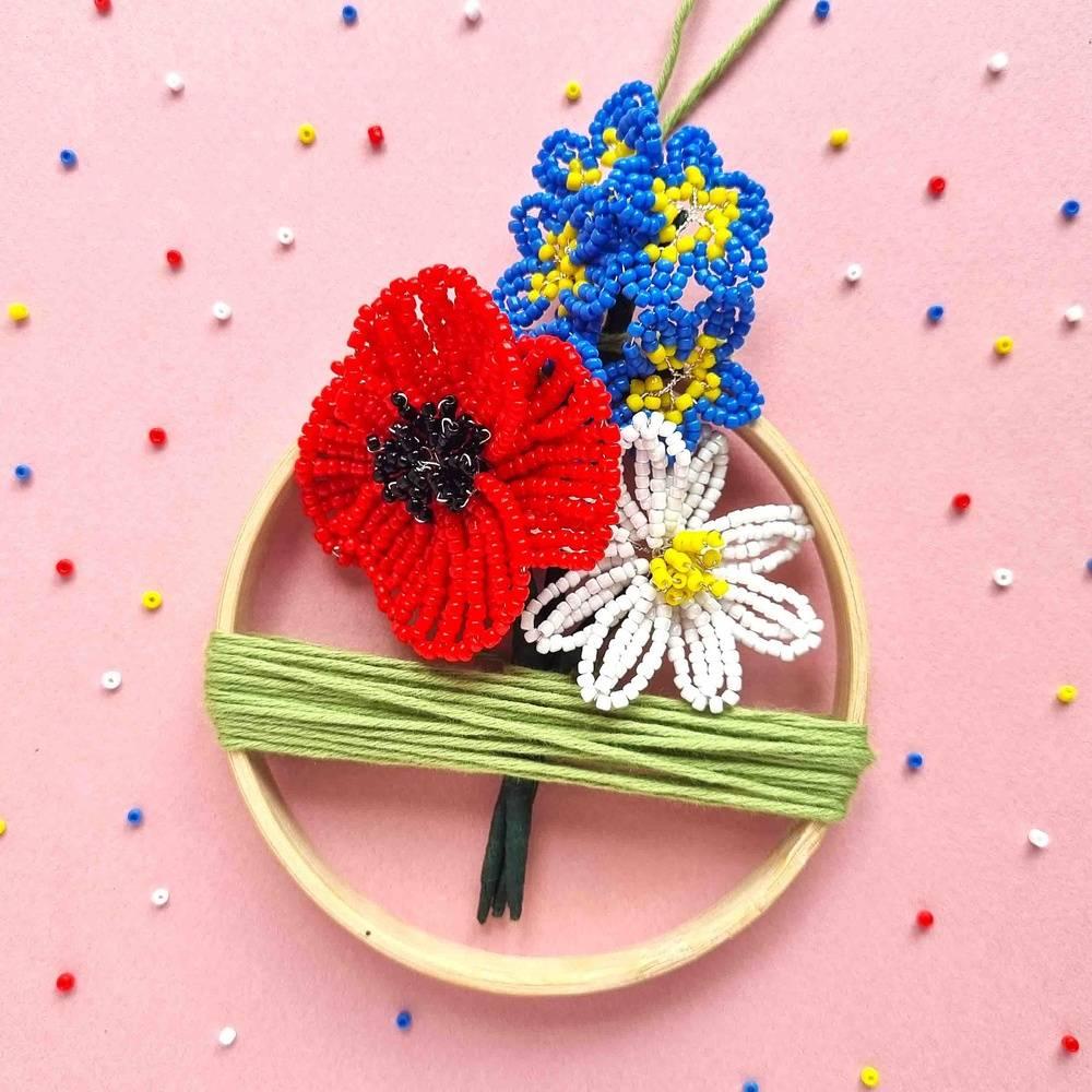 An embroidery hoop with beaded flowers inside