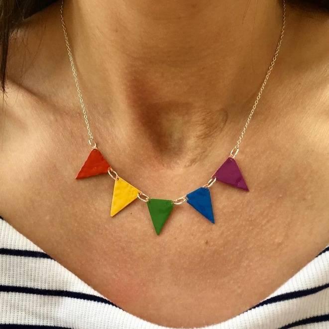 A woman wears a rainbow coloured necklace shaped as a string of bunting.