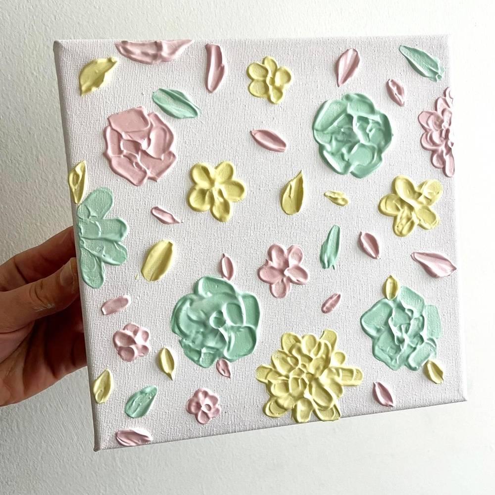 A canvas with pastel-coloured flowers painted on to give a 3D effect